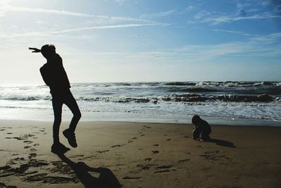 Full length of silhouette man on beach against sky