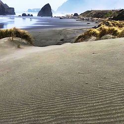 Surface level of sandy beach against sky