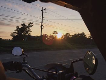 Close-up of hand on bicycle at sunset