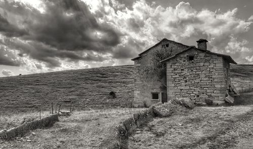 Old building on field against sky