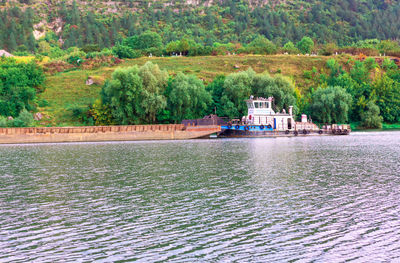 Scenic view of river by trees and building