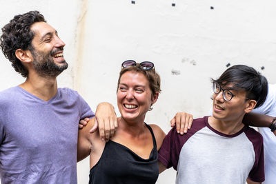 Portrait of happy friends against wall
