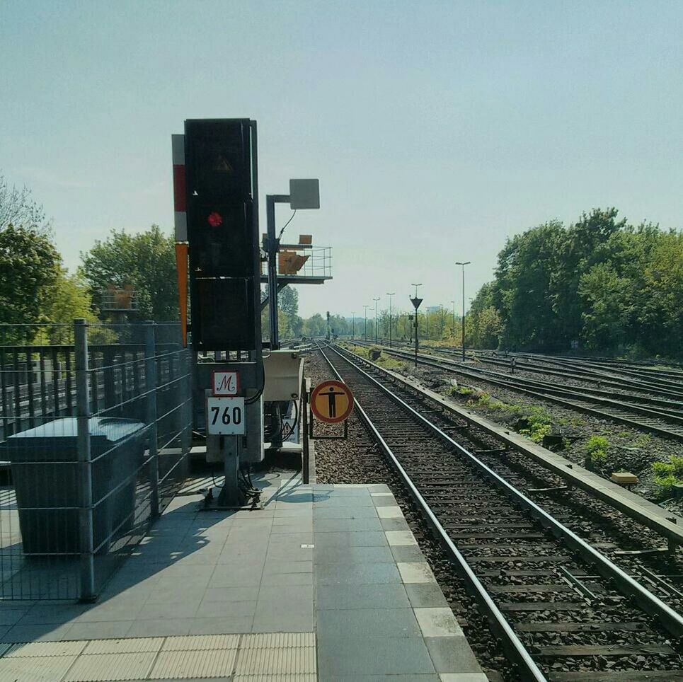 railroad track, rail transportation, transportation, public transportation, railroad station, railroad station platform, clear sky, train - vehicle, built structure, tree, architecture, the way forward, railway track, diminishing perspective, public transport, building exterior, mode of transport, sky, travel, passenger train