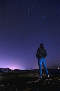 Full length of man standing on field against starry sky