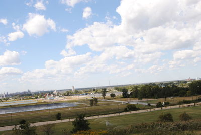 People on grassy field against cloudy sky