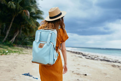 Rear view of woman standing on beach