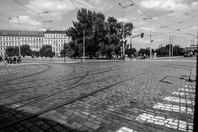 View of railroad tracks by street against sky