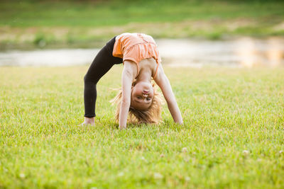 Full length of girl exercising at park