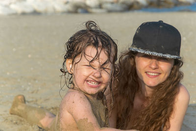 Portrait of smiling mother and daughter at beach