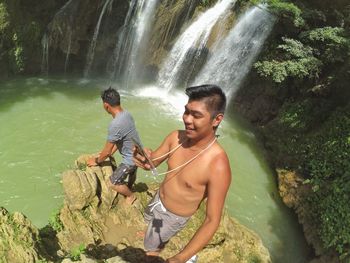 Full length of smiling young woman in water