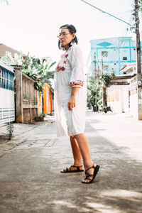 Full length of young woman standing in city