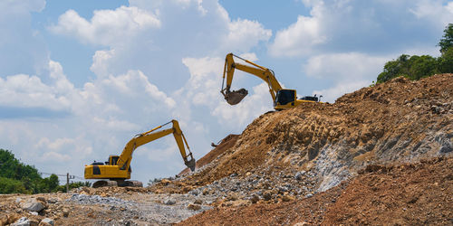 Cranes at construction site against sky