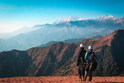 Rear view of man on mountain against sky