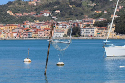 Sailboats moored on sea by town