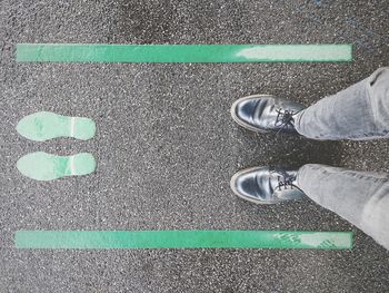 Low section of man standing on road