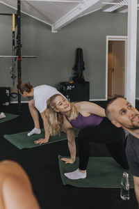 Smiling woman stretching in gym during fitness class