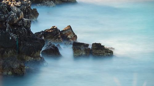 Scenic view of rocks in sea against sky