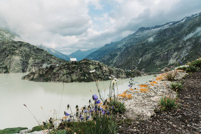 Scenic view of lake by mountains against sky