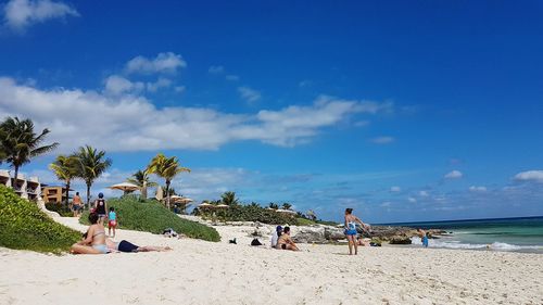 People at beach against sky