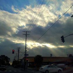 Electricity pylon against cloudy sky