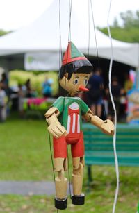 Close-up of toy hanging on grass against sky