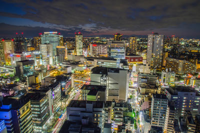 High angle view of illuminated cityscape against sky at night