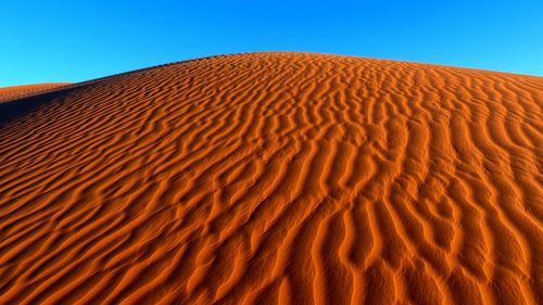 Sand dunes against clear sky