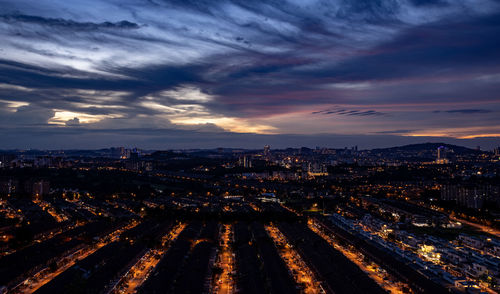 High angle view of illuminated city at sunset
