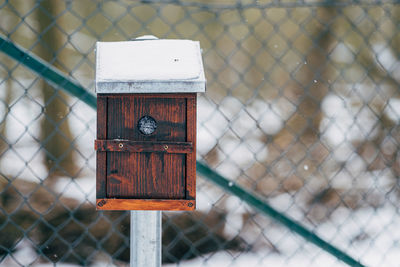 Close-up of birdhouse on wooden fence