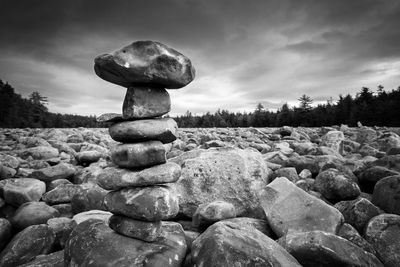 Stack of pebbles on rocks against sky