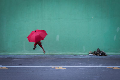 Man with umbrella walking on road