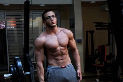 Shirtless muscular young man standing in gym