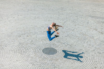 High angle view of woman jumping on sunny day