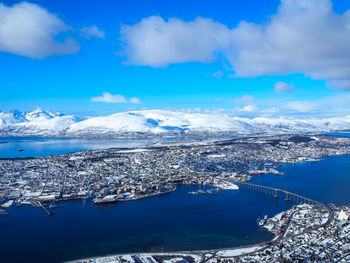 Aerial view of snowcapped mountains against blue sky