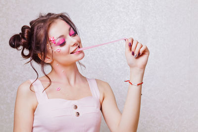 Midsection of woman holding drink against white background