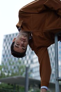 Young man looking away while standing outdoors