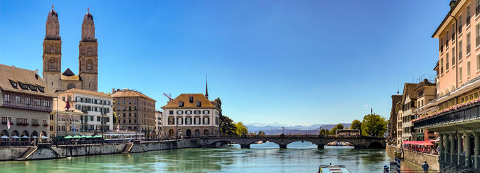 View of zurich with the promenade at limmatquai, the grossmunster and the alps, zurich, switzerland