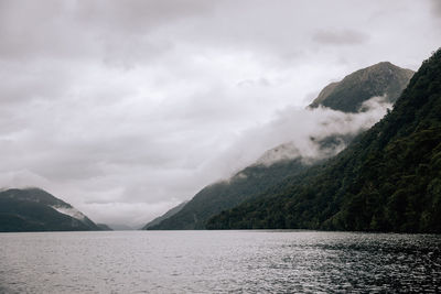 Scenic view of sea and mountains against sky