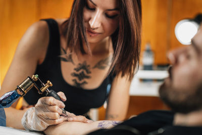 Professional female tattooist working in a tattoo studio