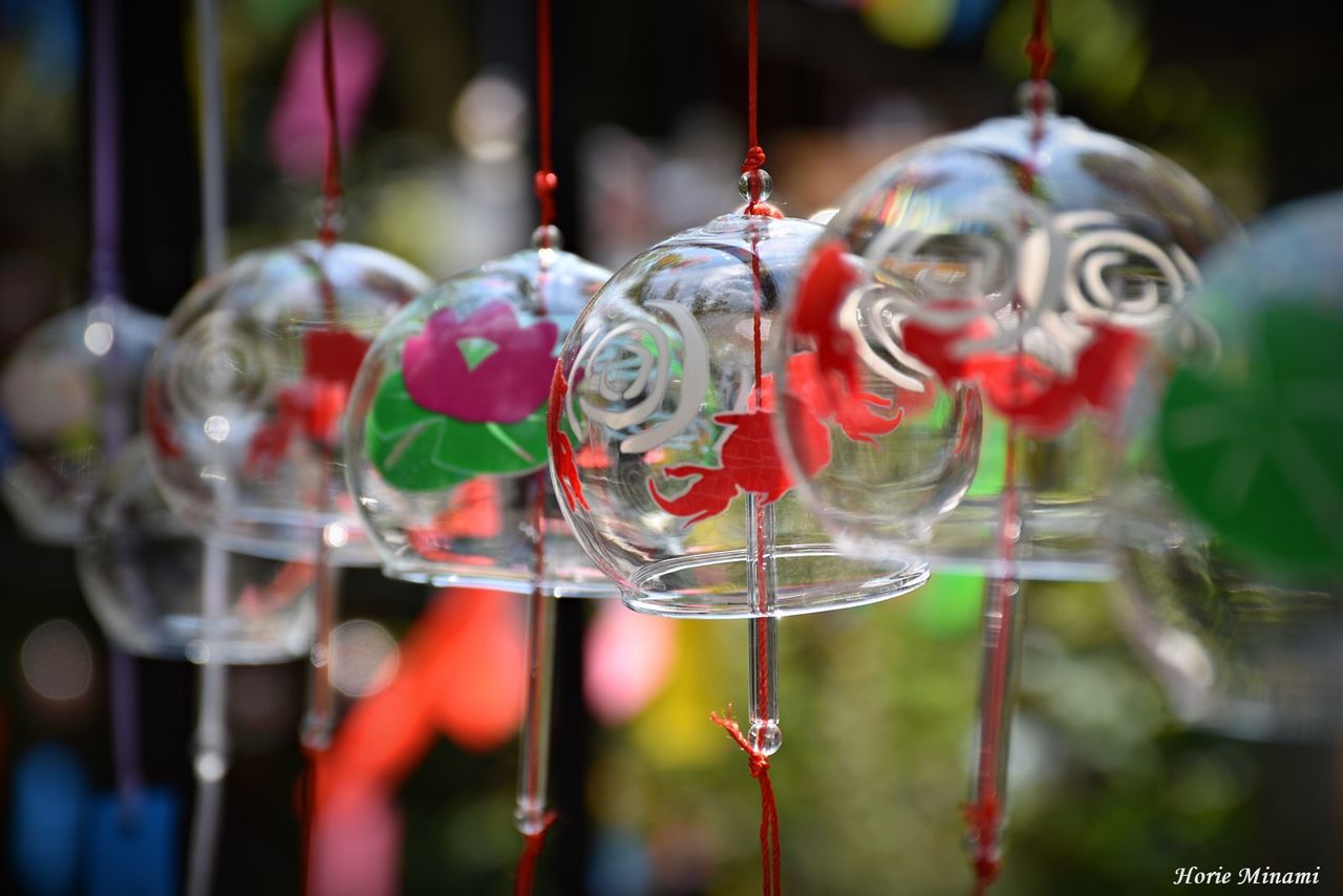 focus on foreground, hanging, no people, decoration, transparent, close-up, day, creativity, art and craft, red, for sale, glass - material, outdoors, bubble, fragility, vulnerability, retail, nature, selective focus, shape