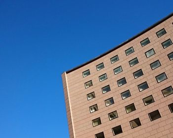 Low angle view of buildings against clear blue sky
