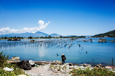 Rear view of people on beach against blue sky