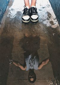 Low section of man standing in puddle