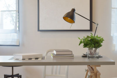 Flower vase on table by window at home