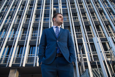 Low angle view of businessman standing against modern building