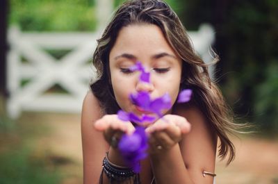 Woman blowing flower petals