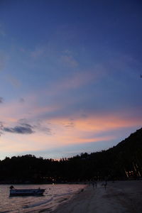 Scenic view of sea against cloudy sky at sunset