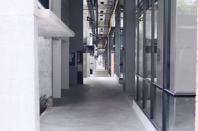 Empty corridor amidst buildings in city