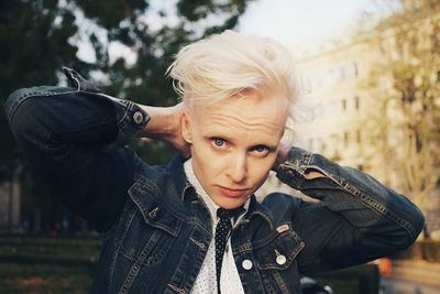 Portrait of woman against trees and building