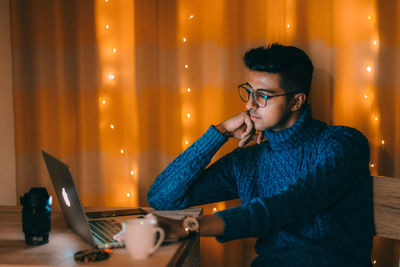 Full length of young man using mobile phone at night